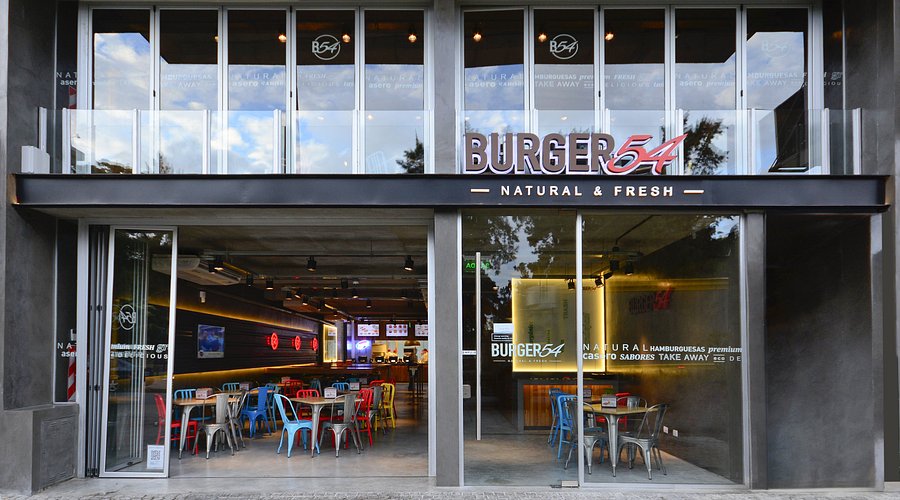 Interior de la sucursal 2 con mesas de madera y decoración temática